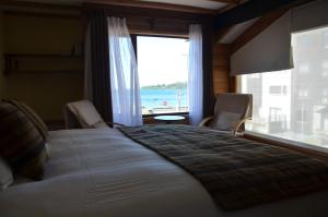 1 dormitorio con 1 cama grande y vistas al océano en Puerto Austral, en Puerto Varas