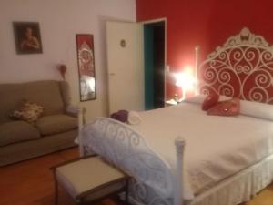 a bedroom with a white bed and a couch at Mi Lugar en el Mundo in Buenos Aires