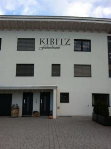 un bâtiment blanc avec un panneau indiquant l'appartement kittikz dans l'établissement Haus Kibitz, à Fieberbrunn