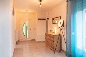 a hallway with a door and a dresser and a lamp at Résidence 3 etoiles Les thèmes Proche Lux, Metz, Cattenom in Hayange