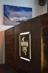 een bord op een muur met een berghut bord bij Mountain Lodge Sedrun in Sedrun