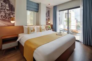 uma cama grande num quarto de hotel com uma janela grande em Little Saigon Boutique Hotel em Cidade de Ho Chi Minh