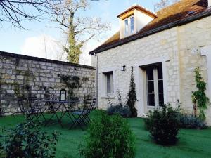 una casa in pietra con un tavolo nel cortile di L'ancien Presbytère a Coye-la-Forêt