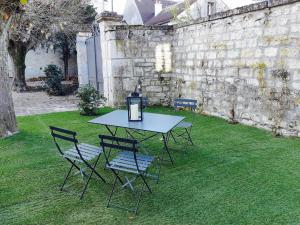 un tavolo e sedie seduti sull'erba in un cortile di L'ancien Presbytère a Coye-la-Forêt