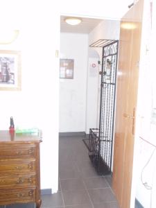 a hallway with a dresser and a black iron gate at L'ancolie in Orelle