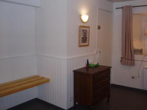 a room with a wooden dresser and a white wall at L'ancolie in Orelle