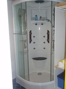 a shower with a glass door in a bathroom at L'ancolie in Orelle