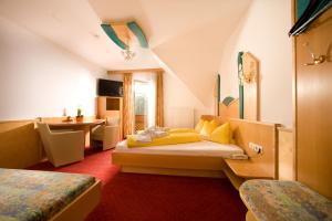 a bedroom with a bed and a desk in a room at Pension Drei-Mäderl-Haus in Unterlamm