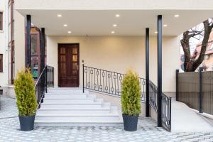 un escalier avec des plantes en pot devant une maison dans l'établissement Pensiunea Select Central, à Târgu-Mureş