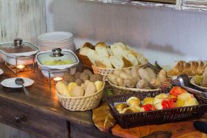 a table with baskets of different types of bread at Pousada Búzios Garden in Búzios