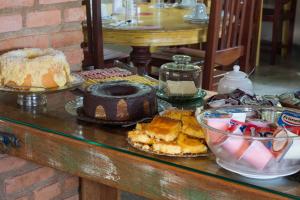 a table with different types of cakes and other desserts at Pousada Búzios Garden in Búzios