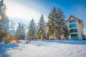 une aire de jeux dans la neige devant un bâtiment dans l'établissement AuRoom Bakuriani Resort, à Bakuriani