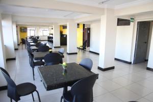 une rangée de tables et de chaises dans une pièce dans l'établissement Hotel Pirâmide Rodoviária, à Salvador