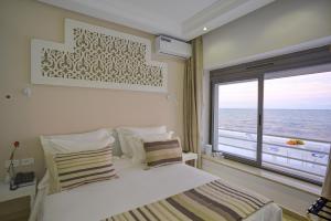 a bedroom with a bed and a large window at Dar Corniche La Marsa (Adults Only) in La Marsa