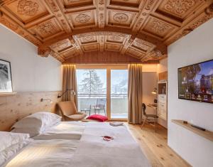 Кровать или кровати в номере Swiss Alpine Hotel Allalin