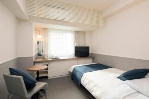 1 dormitorio con 1 cama y escritorio con ordenador en Hotel Plaza Osaka, en Osaka