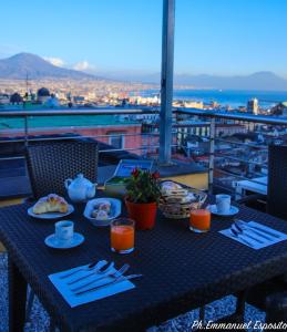 une table avec des assiettes de nourriture sur un balcon dans l'établissement B&B Nel Regno di Napoli, à Naples