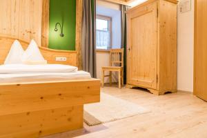 1 dormitorio con cama y pared verde en Das kleine Bio Hotel Tiefenbach, en Schladming