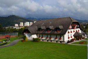 una gran casa blanca con césped verde en Mini Hotel, en Škofja Loka