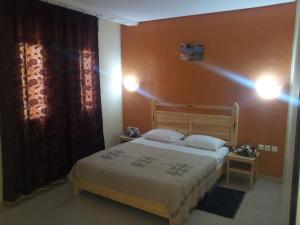 a bedroom with a bed and a red wall at Résidence El Arich in Tozeur