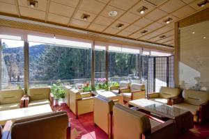 un restaurante con mesas y sillas y una gran ventana en Hotel Seikoen, en Nikko