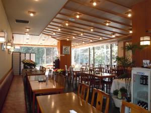 un restaurante con mesas y sillas de madera y ventanas en Hotel Seikoen, en Nikko