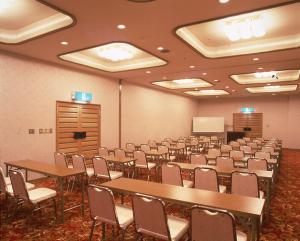 una sala de conferencias con mesas y sillas y un podio en Hotel Seikoen, en Nikko