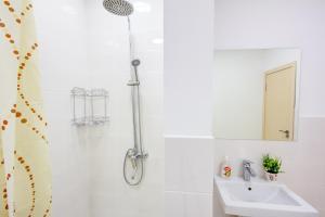 ein Bad mit einer Dusche und einem Waschbecken in der Unterkunft WHITE HOTEL & HOSTEL in Bischkek