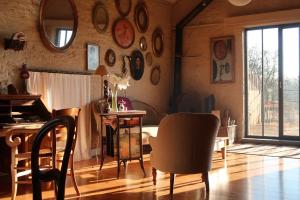 a living room with a table and chairs and a room with a window at La Passiflore B&B in Bossière