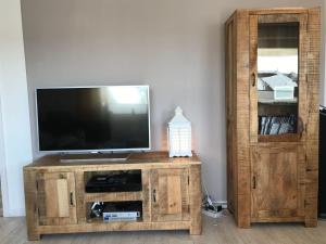 een houten entertainmentcentrum met een flatscreen-tv bij Seebrise-Sylt in Westerland