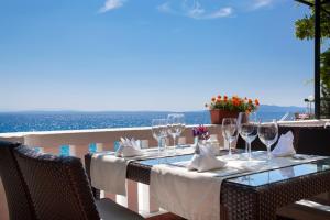 tavolo con bicchieri da vino e vista sull'oceano di Hotel Kristal - Liburnia a Opatija