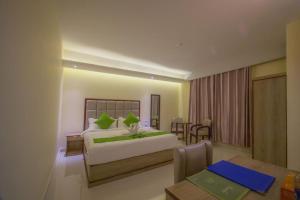 a hotel room with a bed and a dining room at Hotel Mira Garden in Sylhet