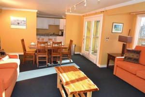 a living room with a table and a dining room at Luxurious Trailside Village One Bedroom Condo #1 in Killington