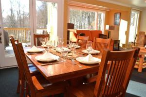 a wooden table with glasses and plates on it at Luxurious Trailside Village One Bedroom Condo #1 in Killington