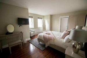 una camera con letto, scrivania e specchio di West Haven House a Doolin