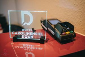 a remote control sitting on a red table with a hotel at Hotel Carolinensiel Doan in Carolinensiel