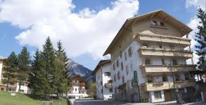 een groot wit gebouw met een puntdak bij Albergo Genziana in San Vigilio Di Marebbe