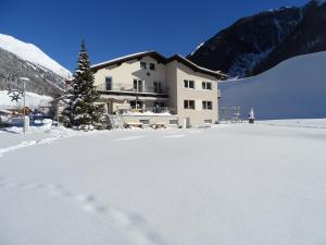 a building in the snow with a christmas tree at Apart Tyrol in Umhausen