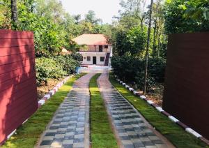 a cobblestone path in front of a house at The Brown and Brew Homestay in Chikmagalūr