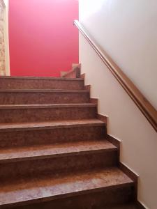 un escalier avec un mur rouge dans l'établissement Aktaion Hotel, à Monemvasia