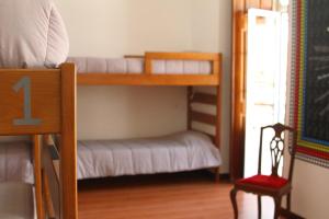 a bunk bed room with two bunk beds and a chair at Hostel 2300 Thomar in Tomar