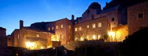 un grand bâtiment avec des lumières allumées la nuit dans l'établissement Likinia Hotel, à Monemvasia