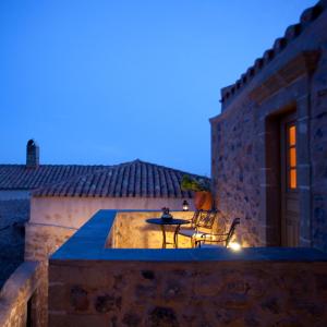 un patio extérieur avec une table et des chaises la nuit dans l'établissement Likinia Hotel, à Monemvasia