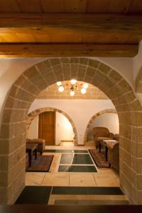 une arche dans un bâtiment avec des chaises et des tables dans l'établissement Likinia Hotel, à Monemvasia