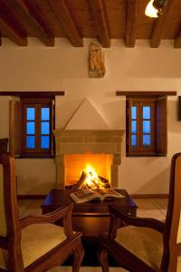 - un salon avec une cheminée, une table et des chaises dans l'établissement Likinia Hotel, à Monemvasia