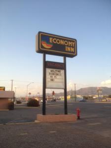 ein Schild für ein Economy Inn auf einem Parkplatz in der Unterkunft Economy Inn Alamogordo in Alamogordo