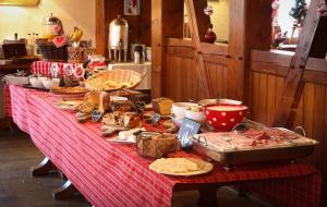 une table avec un tissu de table rouge et de la nourriture dans l'établissement The Originals Boutique, Hôtel La Ferme du Pape, Eguisheim, à Eguisheim