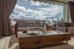 uma sala de estar com uma mesa e um copo de vinho em White Angel Hotel em Breuil-Cervinia