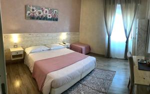 um quarto de hotel com uma cama grande e uma janela em Fiumicino Airport B&B Deluxe em Fiumicino