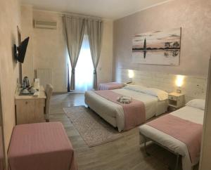 um quarto de hotel com duas camas e uma janela em Fiumicino Airport B&B Deluxe em Fiumicino